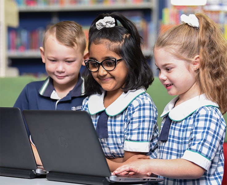 Three students working on laptop computers