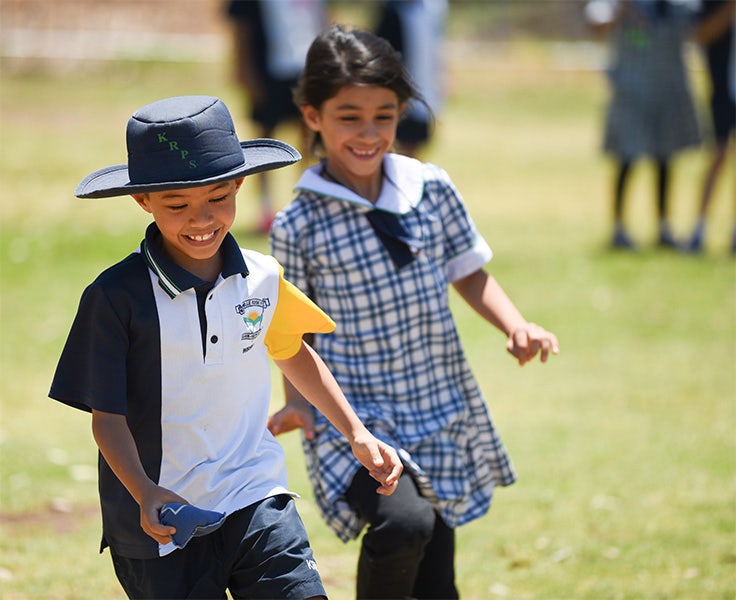 Two students playing sport on the school field